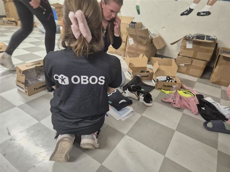 a person holding a person's hair in a room full of boxes