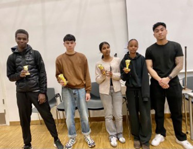 en gruppe mennesker som holder trofeer